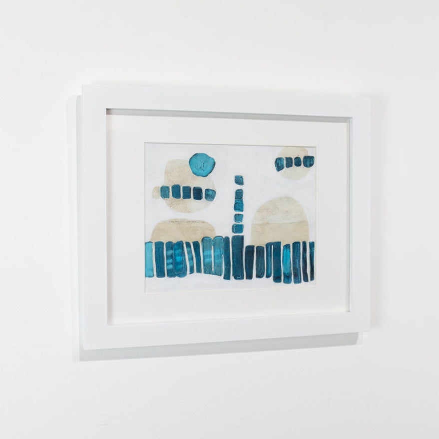A blue, white, and beige abstract painting framed in a white frame hangs on a white wall.