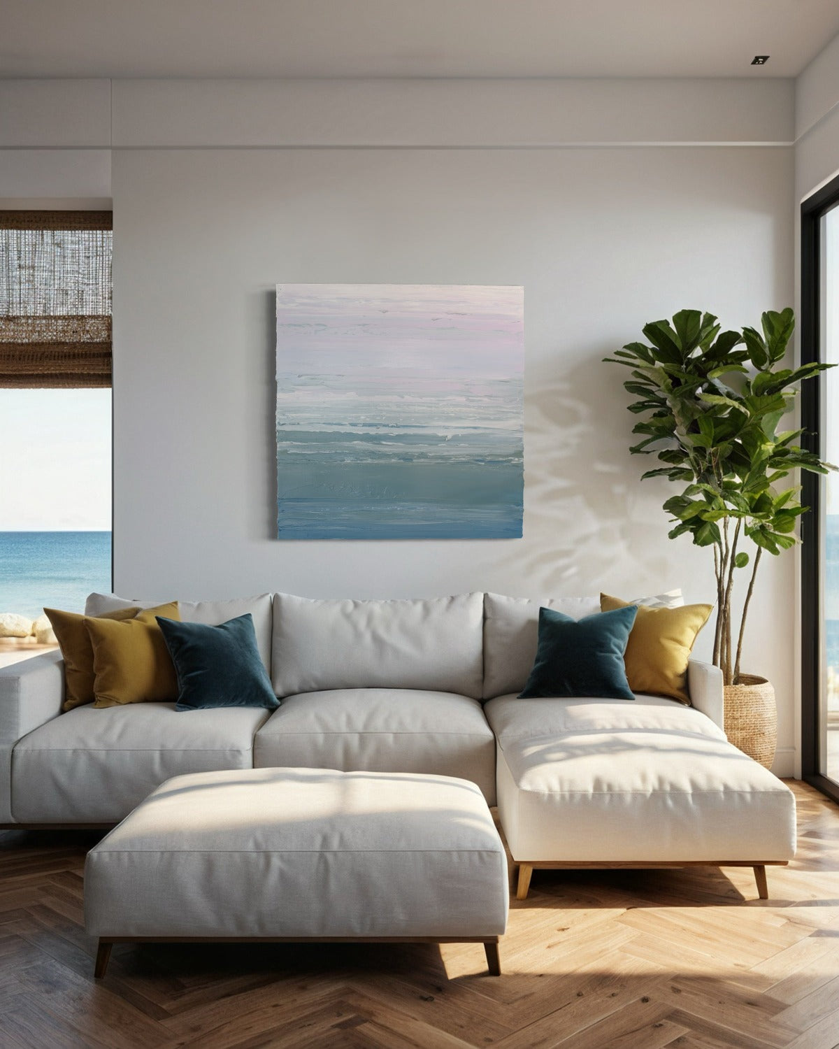 A teal blue, teal green, lavender and pale lavender textured abstract painting by Teodora Guererra hangs on a wall above a cream colored sectional with windows on either side and s large fica tree to the right.