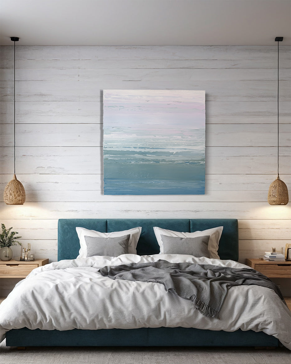 A teal blue, teal green, lavender and pale lavender textured abstract painting by Teodora Guererra hangs on a wall above a queen bed with a teal velvet headboard. White and grey bed linens dress the bed and 2 wicker lamps hang on either side.