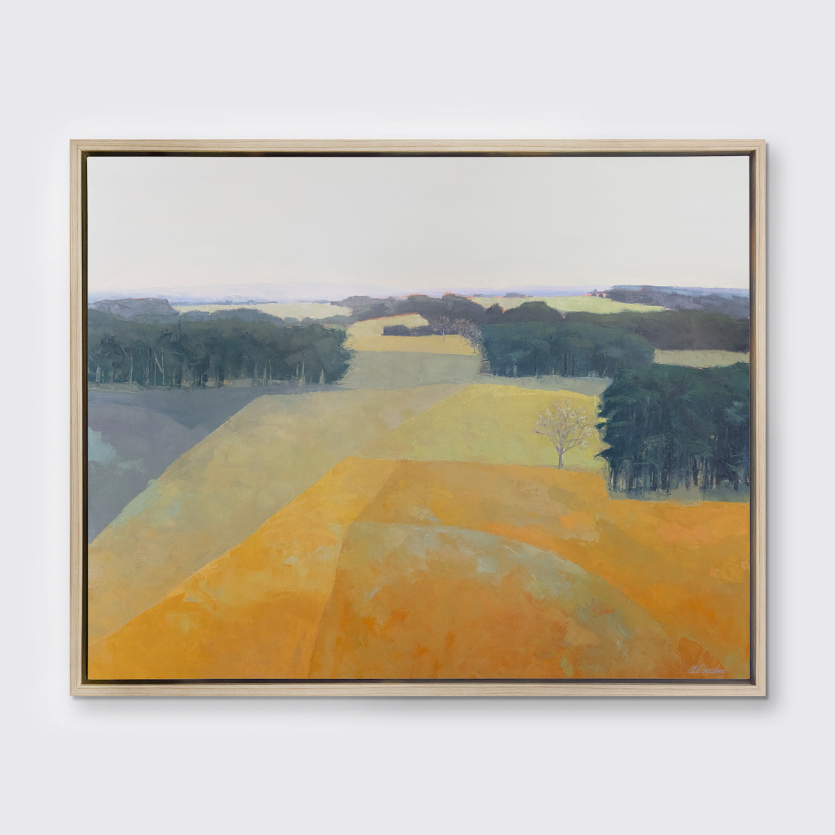 A light blue, green and light orange abstract landscape print in a white oak wood floater frame hangs on a white wall.