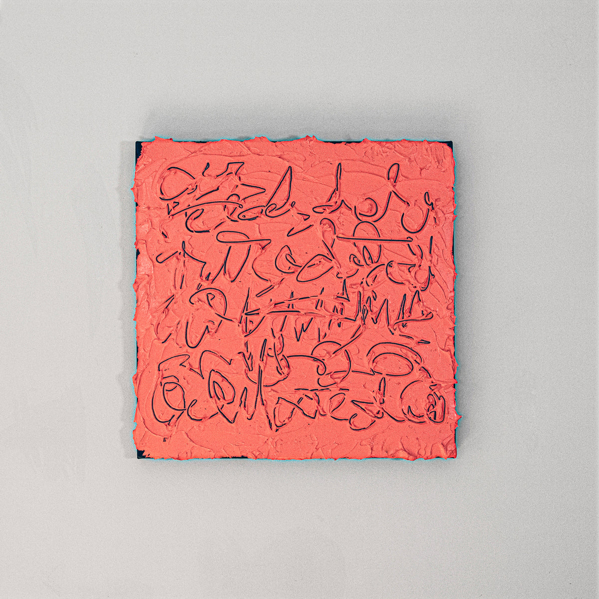 A square abstract canvas painting featuring textured coral pink paint with navy scribbled lines, displayed against a neutral light gray wall.