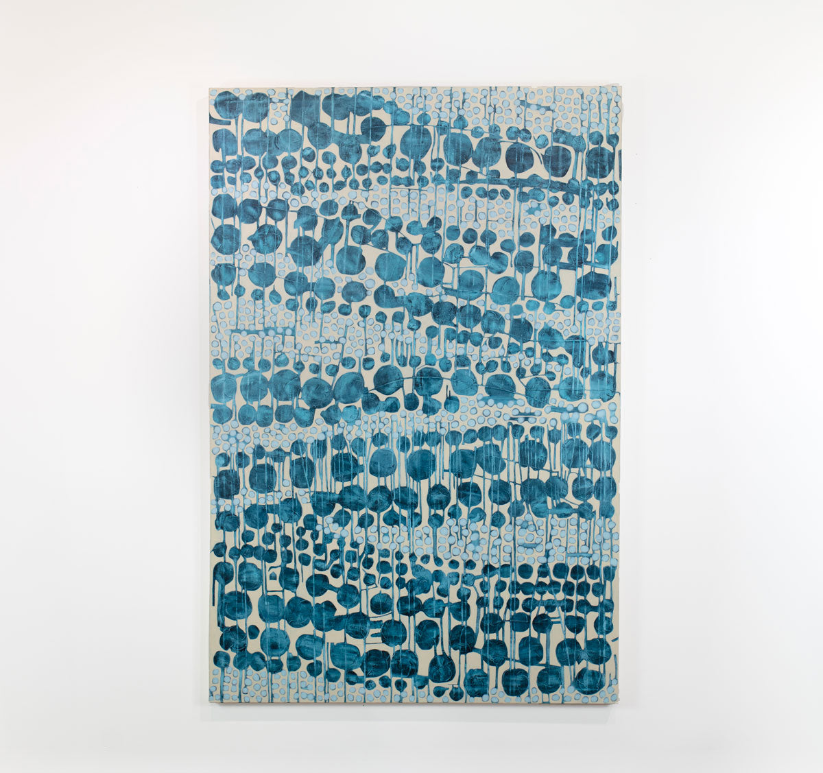An abstract blue and beige painting hangs on a white wall.