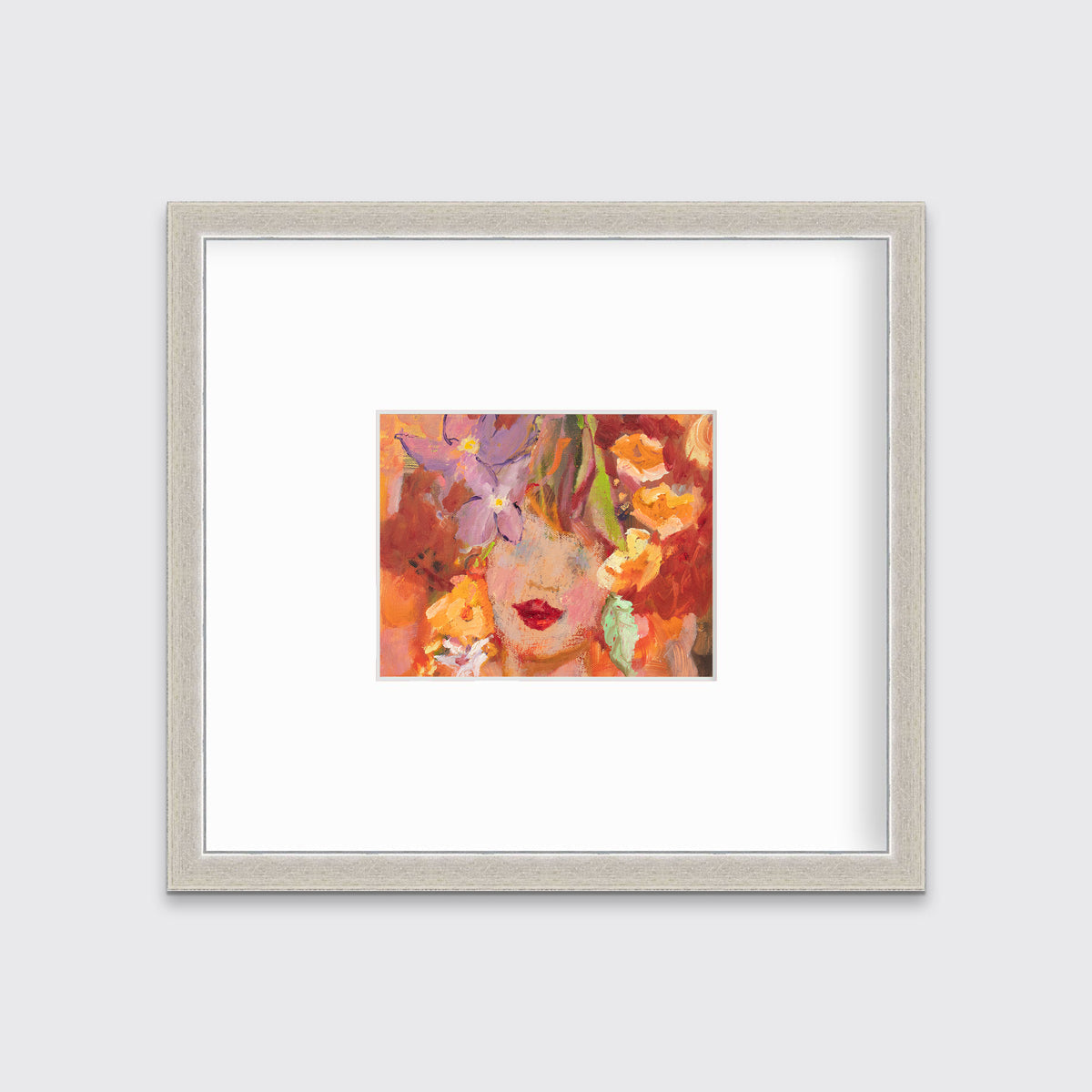 A red, orange, yellow and purple figural print in a silver frame with a mat hangs on a white wall.