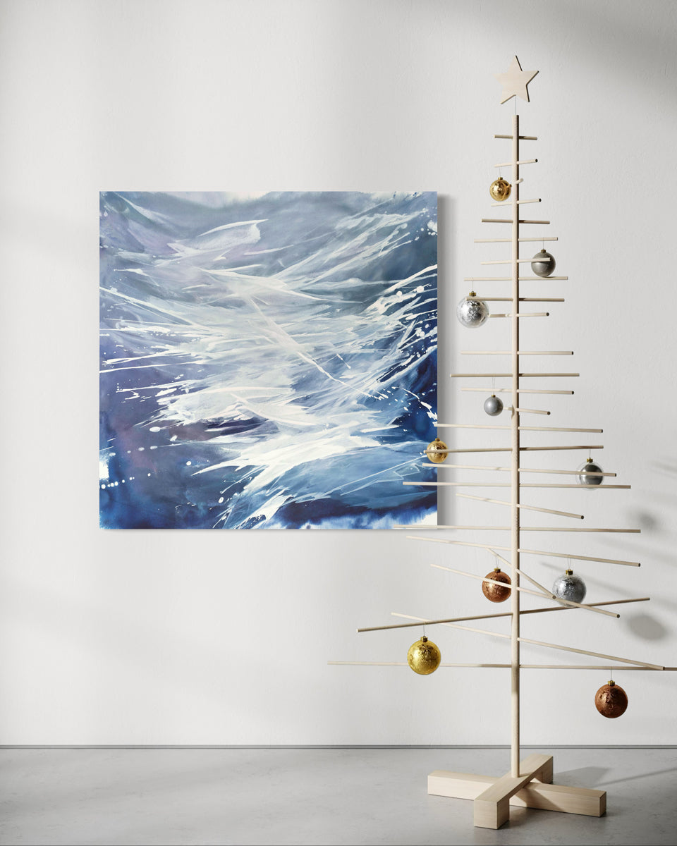Decorative Christmas tree with ornaments against a white wall with and original abstract painting by Teo Guererra.
