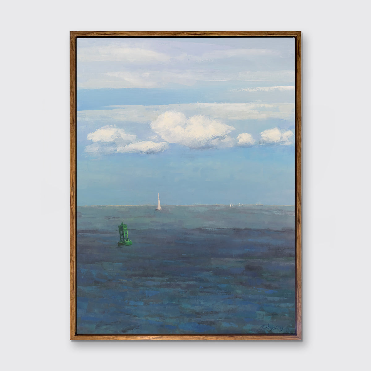 A coastal seascape print in an oak wood floater frame hangs on a white wall.