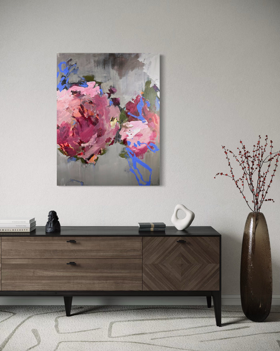 Abstract floral painting on a wall above a wooden console table.