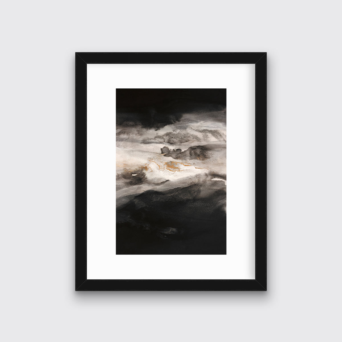 A black, white, beige and gold abstract print in a black frame with a mat hangs on a white wall.