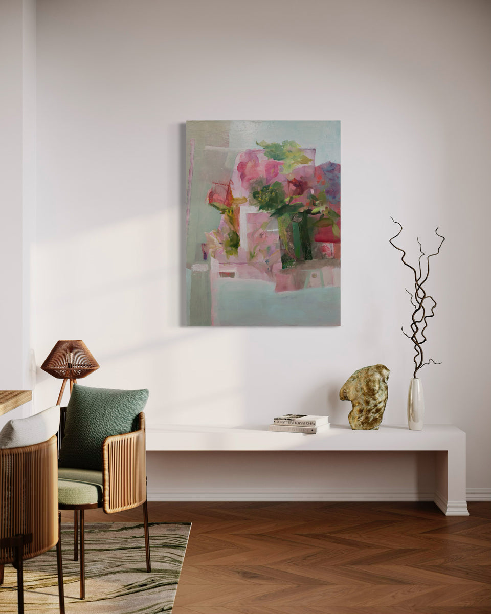A painting depicting a green vase full of lush, pink roses and peonies is hung above a bench. This painting is wired and ready to hang.