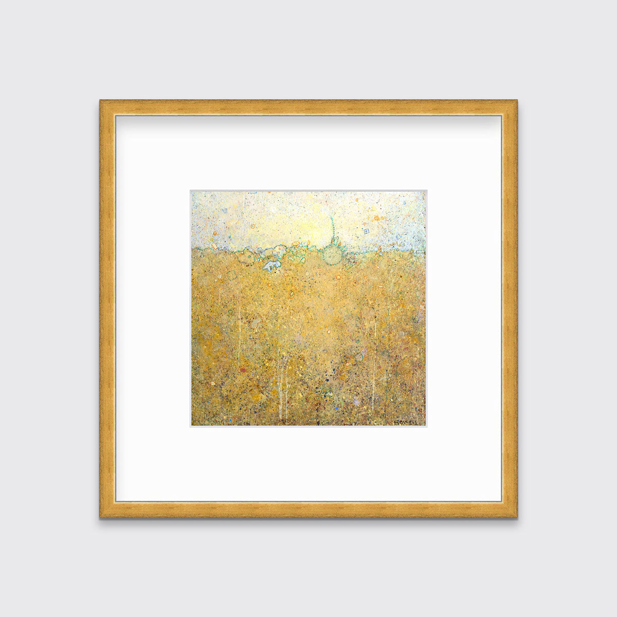 A yellow abstract landscape print in a gold frame with a mat hangs on a white wall.