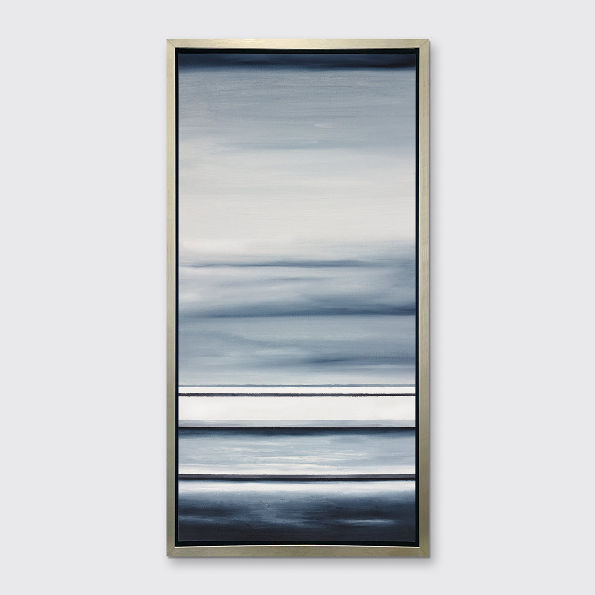 Different sized bands of hues of blue and white in a silver floater frame on a wall.