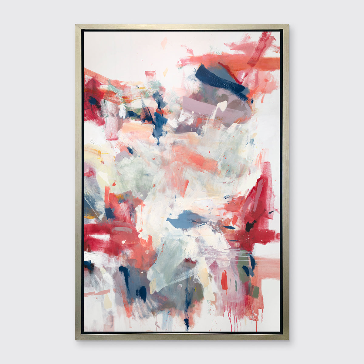 A pink, blue and white abstract print in a silver floater frame hangs on a white wall.