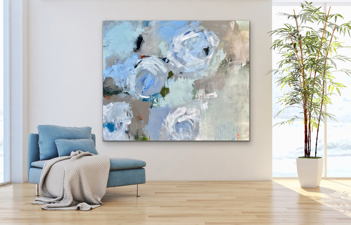 Abstract floral painting on a wall in a living room with a blue armchair and plant.