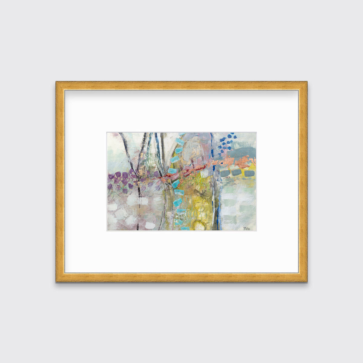 A multicolored abstract print in a gold frame with a mat hangs on a white wall.