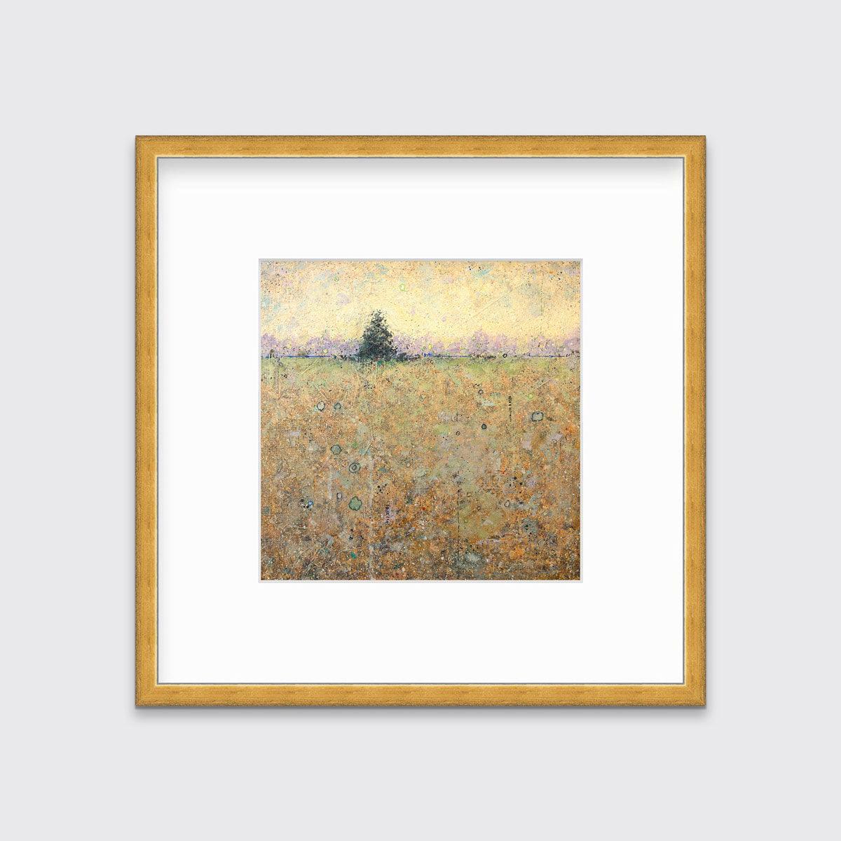 A green, orange and yellow abstract landscape print in a gold frame with a mat hangs on a white wall.