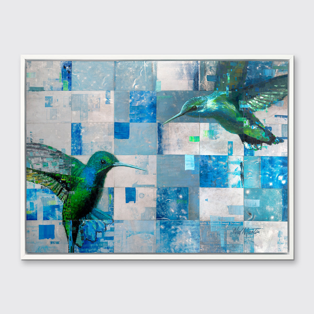 A blue and green abstract hummingbird print in a white floater frame hangs on a white wall.