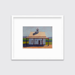 A contemporary house print in a white frame with a mat hangs on a white wall.