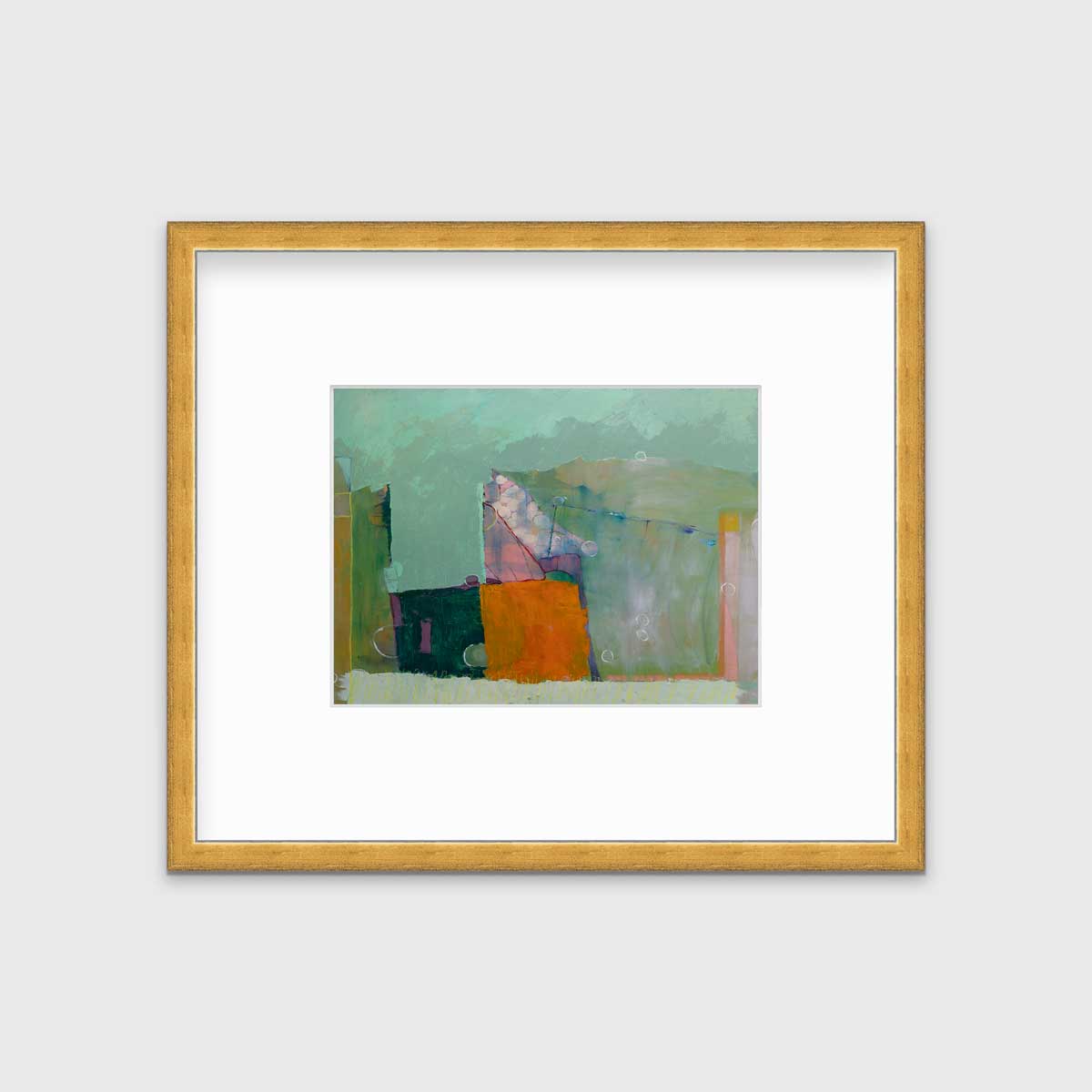 A green abstract print by Christine Averill-Green in a gold frame with a mat hangs on a white wall.