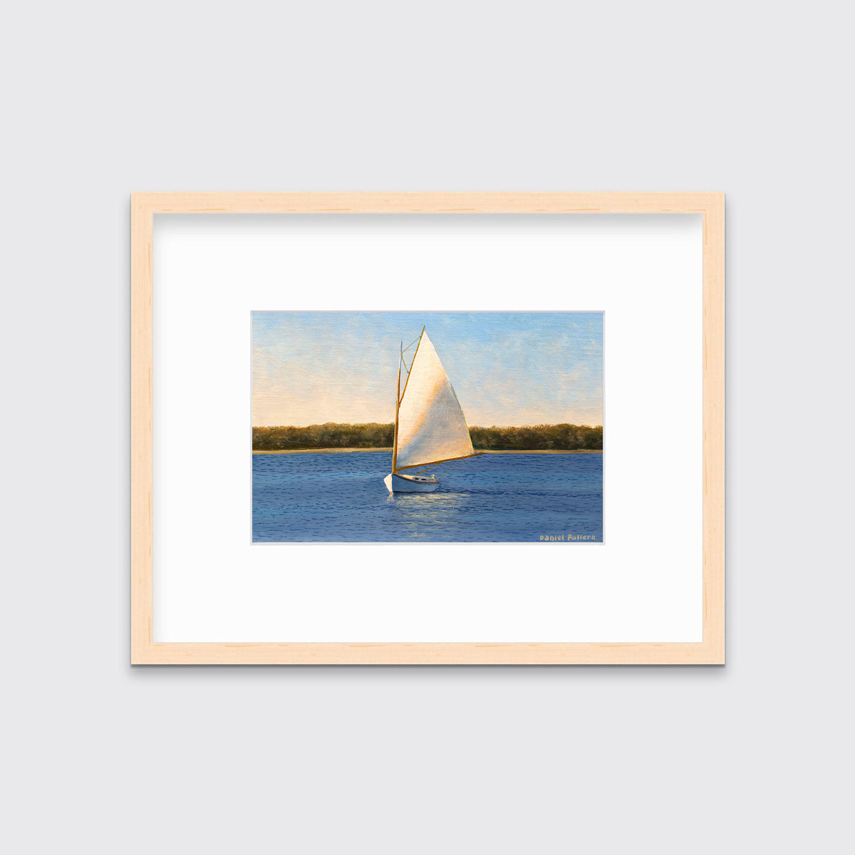 A blue and beige contemporary seascape print with a sailboat in a natural wood frame with a mat hangs on a white wall.