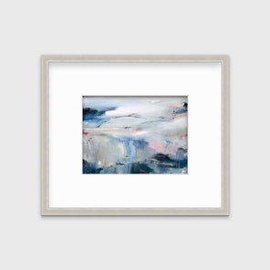 A blue abstract print in a silver frame with a mat hangs on a white wall.