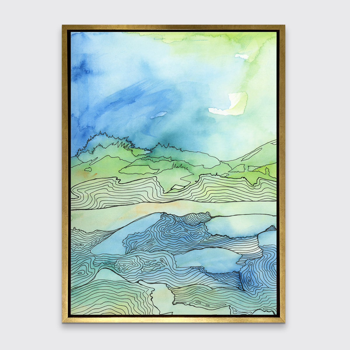 A blue and green abstract canvas print framed in a gold floater frame hangs on a grey wall.