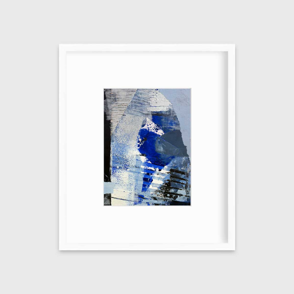 A blue, white and black abstract print in a white frame with a mat hangs on a white wall.