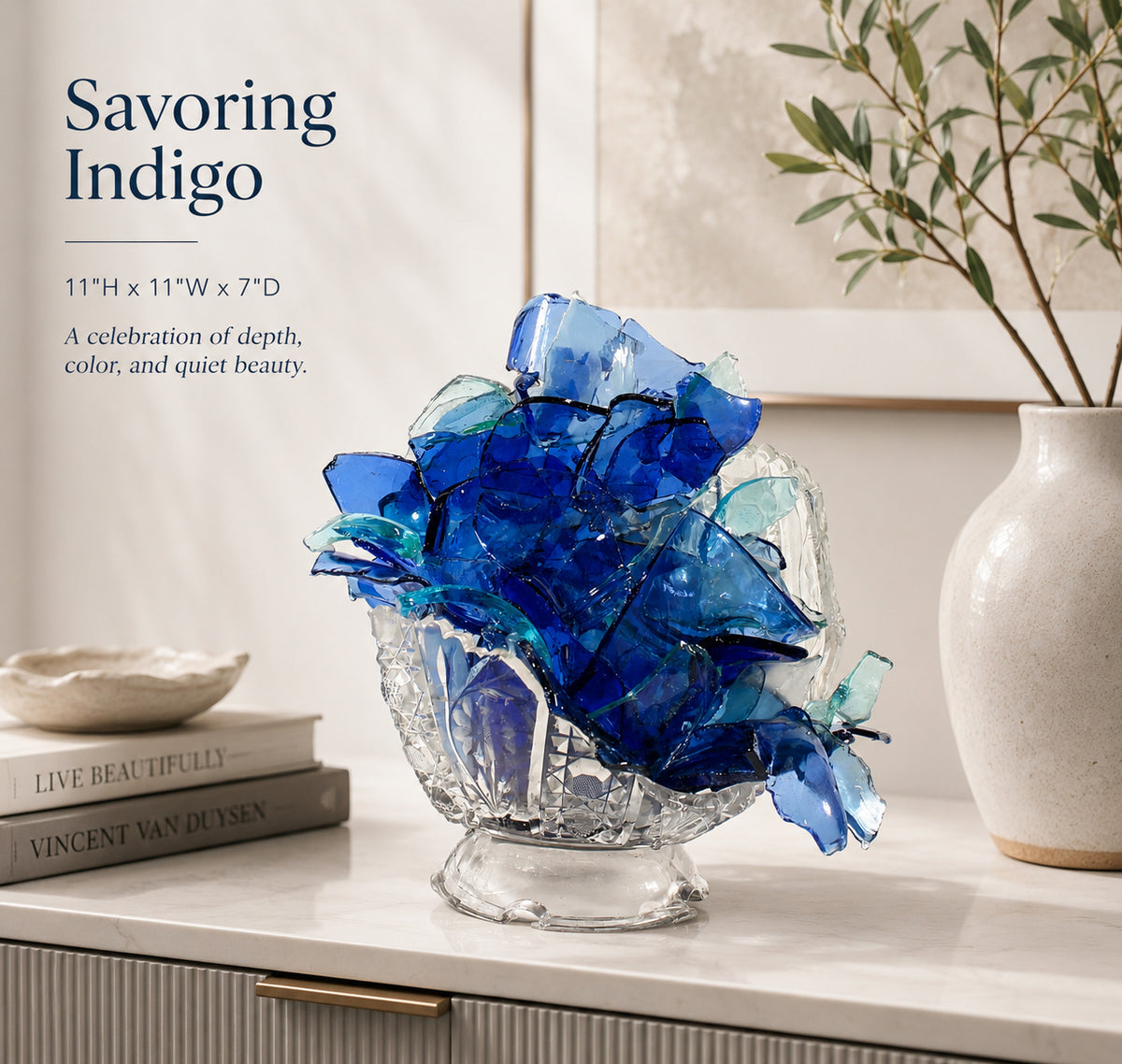 Glass sculpture of a flower made from blue glass pieces on a shelf with text about 'Savoring Indigo'.