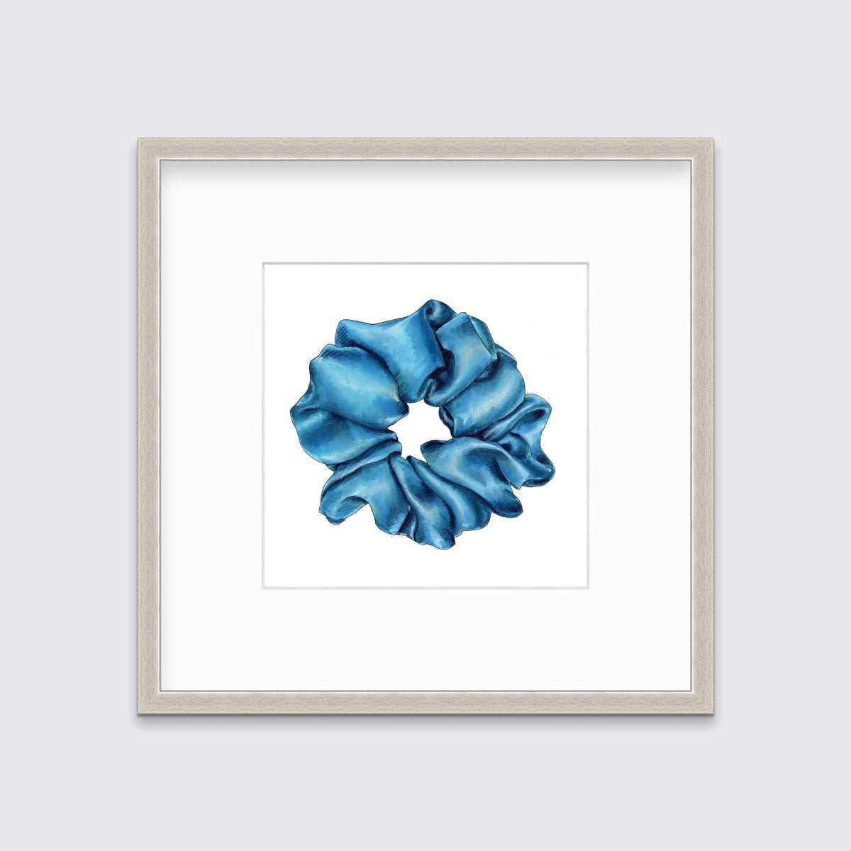 A drawing of a blue hair scrunchie framed in a silver frame hangs on a white wall.
