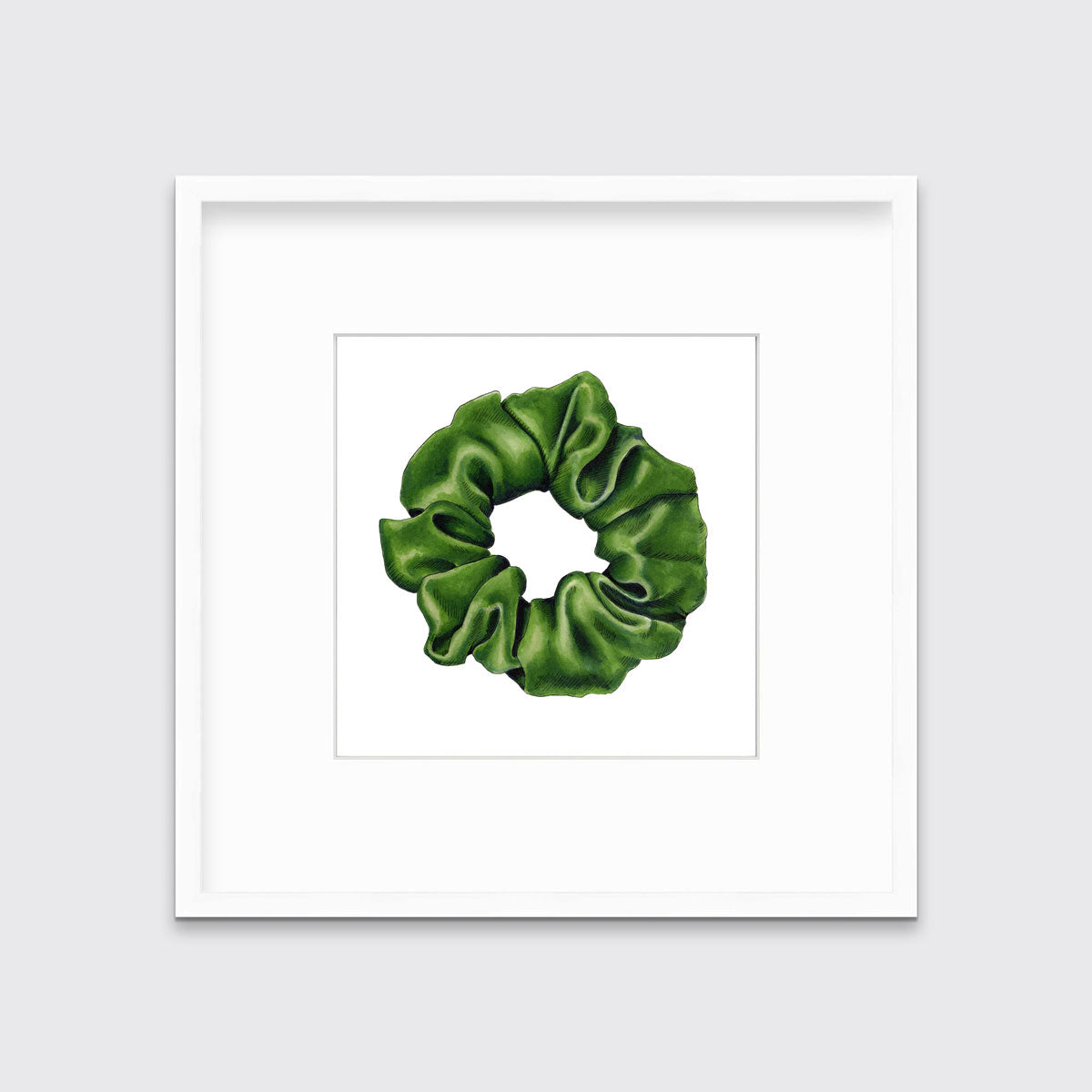 A drawing of a green hair scrunchie framed in a white frame hangs on a white wall.