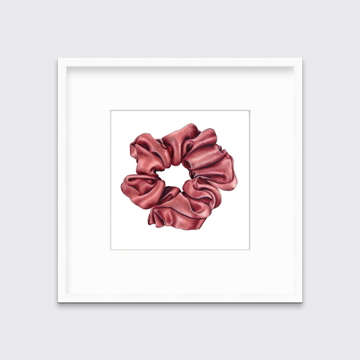 A drawing of a pink hair scrunchie framed in a white frame hangs on a white wall.