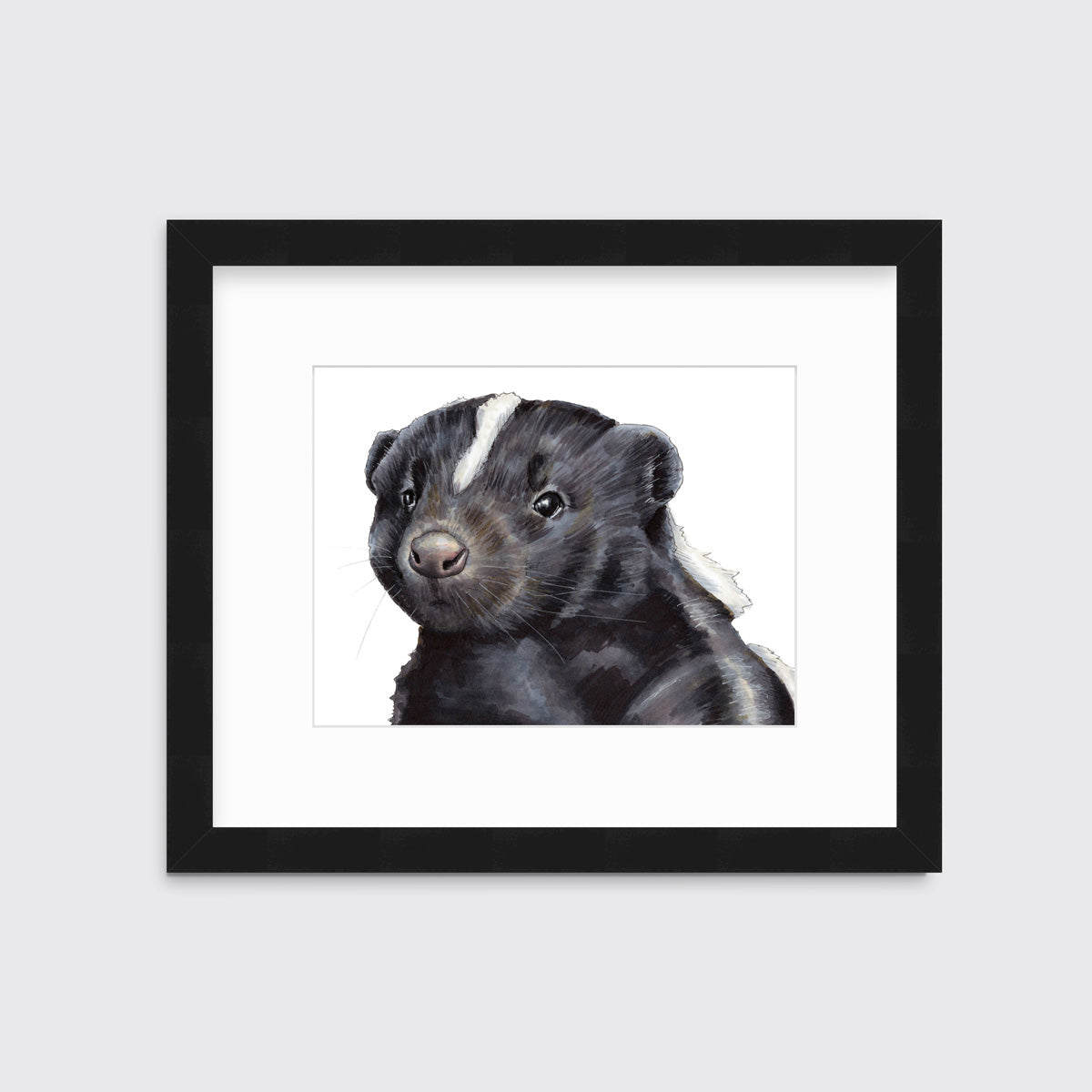 An illustration of a skunk framed in a black frame hangs on a white wall.