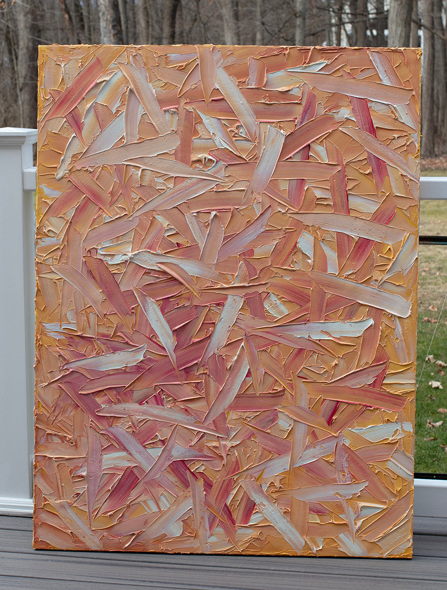 A orange, pink, coral and white textured abstract painting sits on the artists deck.