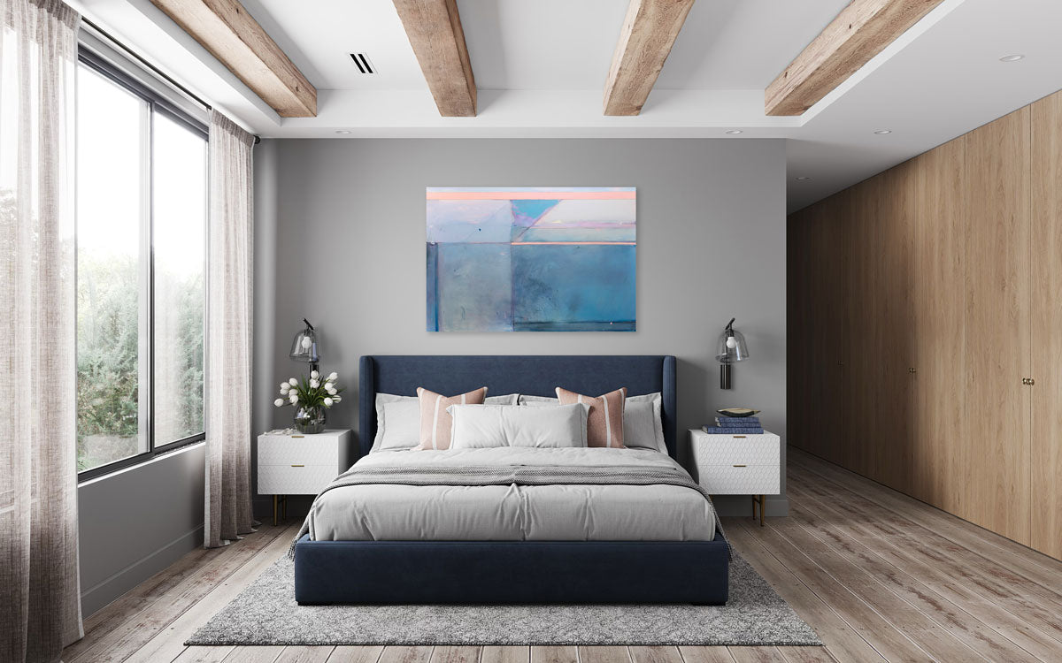 A blue and pink abstract painting hangs on a grey wall above a navy blue and grey bed and white end tables.