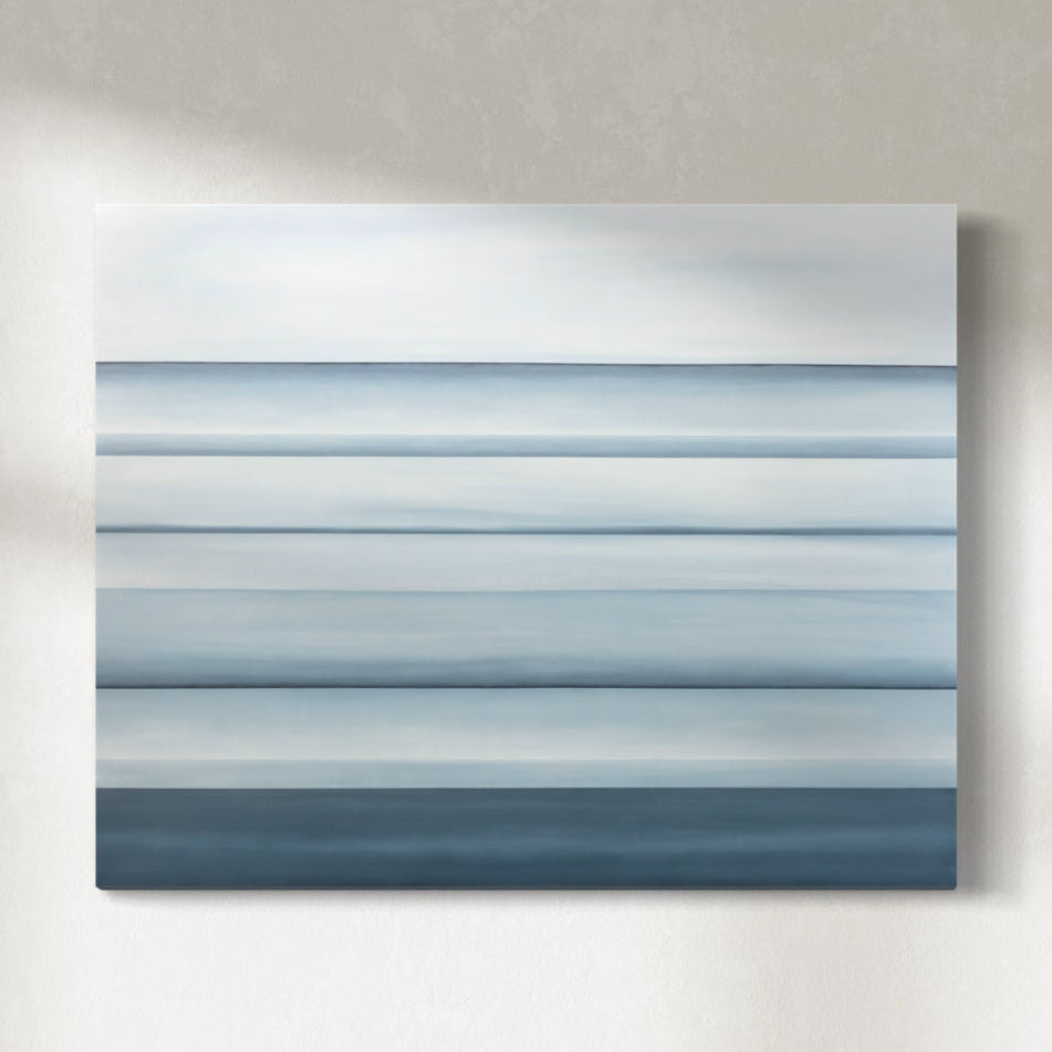 A coastal painting hangs on a light grey wall.