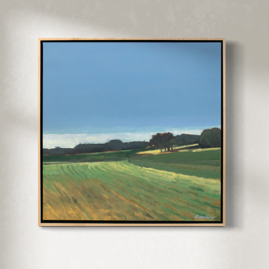 A green and blue abstracted landscape painting in a light wood frame hangs on a white wall.