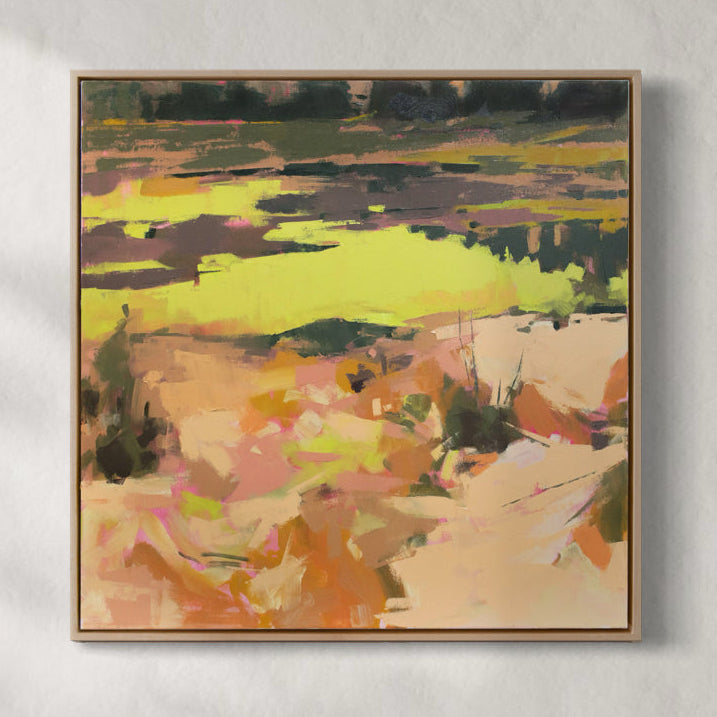 A yellow and orange abstract landscape painting hangs on a white wall.