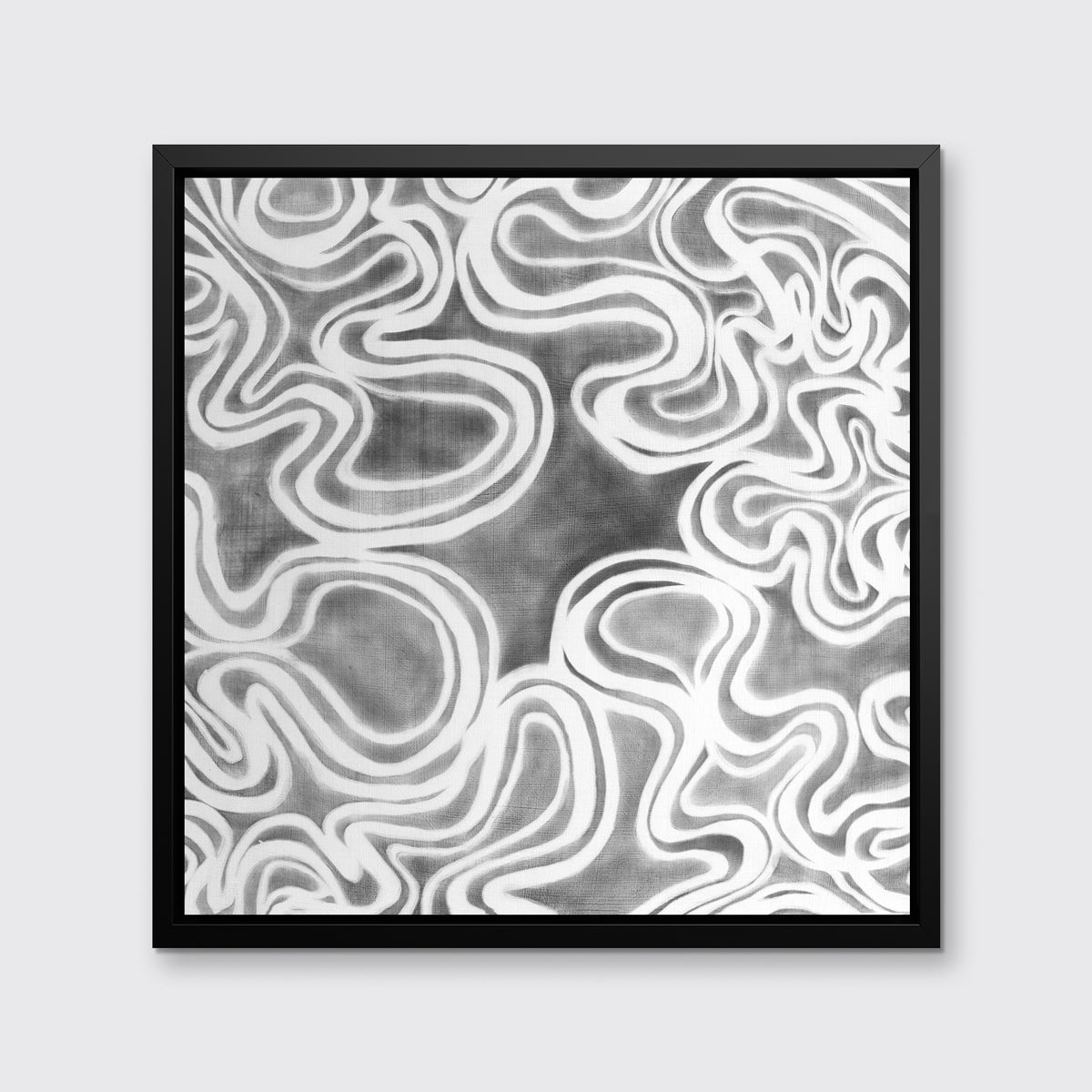 A grey and white abstract print in a black floater frame hangs on a white wall.