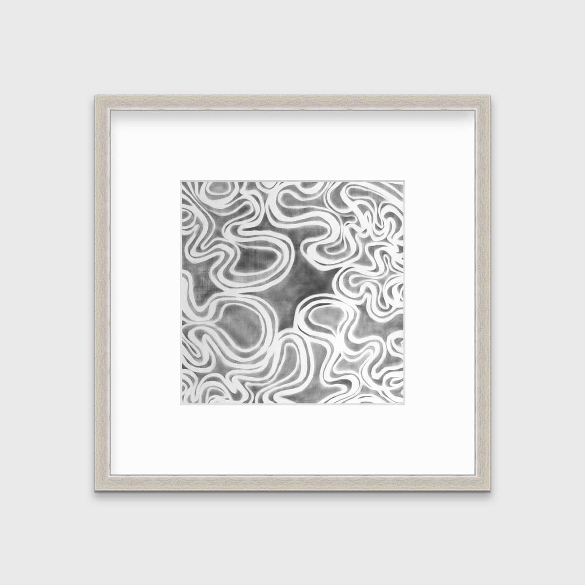 A grey and white abstract print in a silver frame with a mat hangs on a white wall.