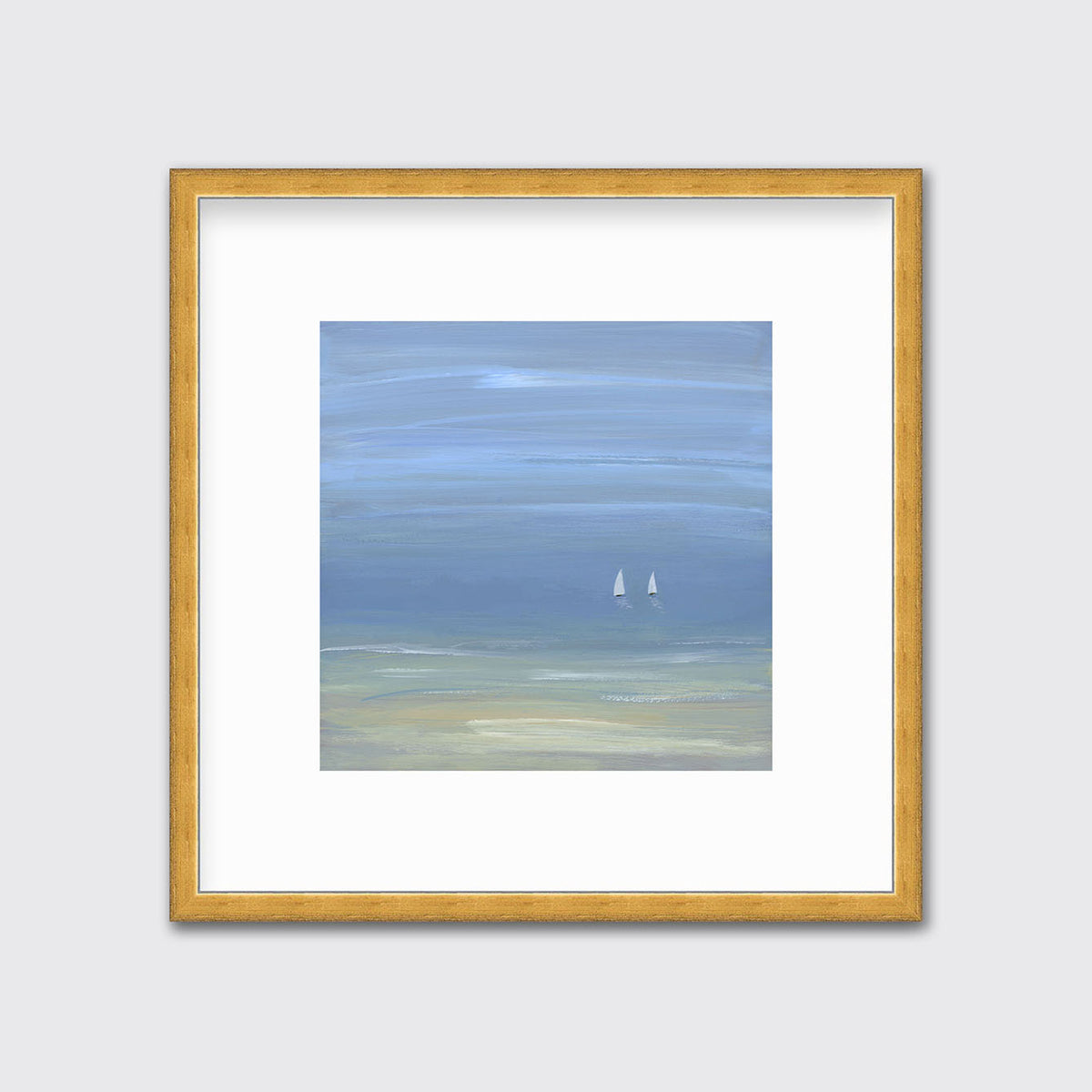 A blue, beige and white abstract seascape print with two small sailboats in a gold frame with a mat hangs on a white wall.