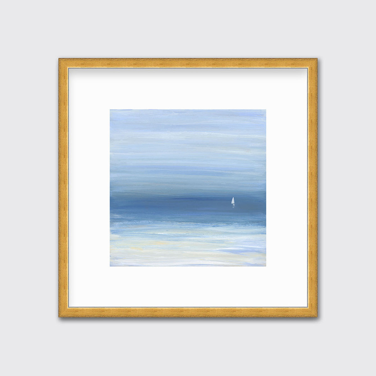 A blue, beige and white abstract seascape print with a small sailboat in a gold frame with a mat hangs on a white wall.