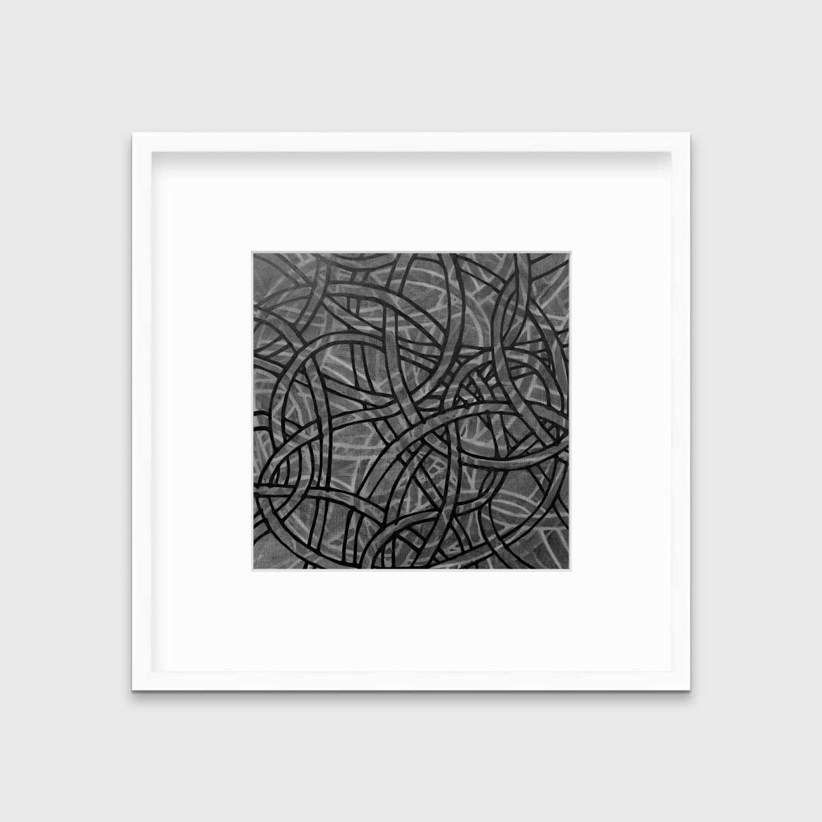 A grey, black and white abstract print in a white frame with a mat hangs on a white wall.