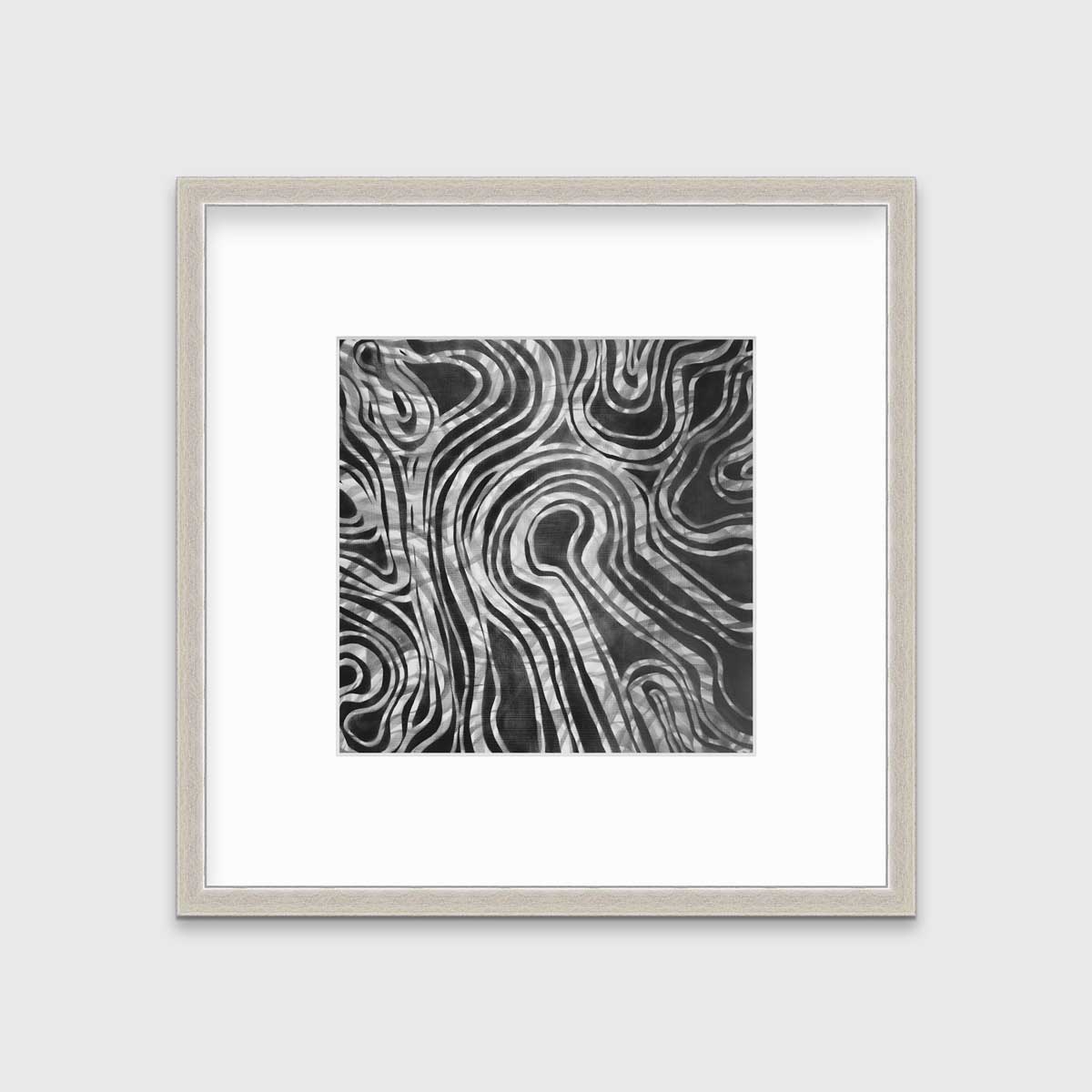 A dark grey and white abstract print in a silver frame with a mat hangs on a white wall.