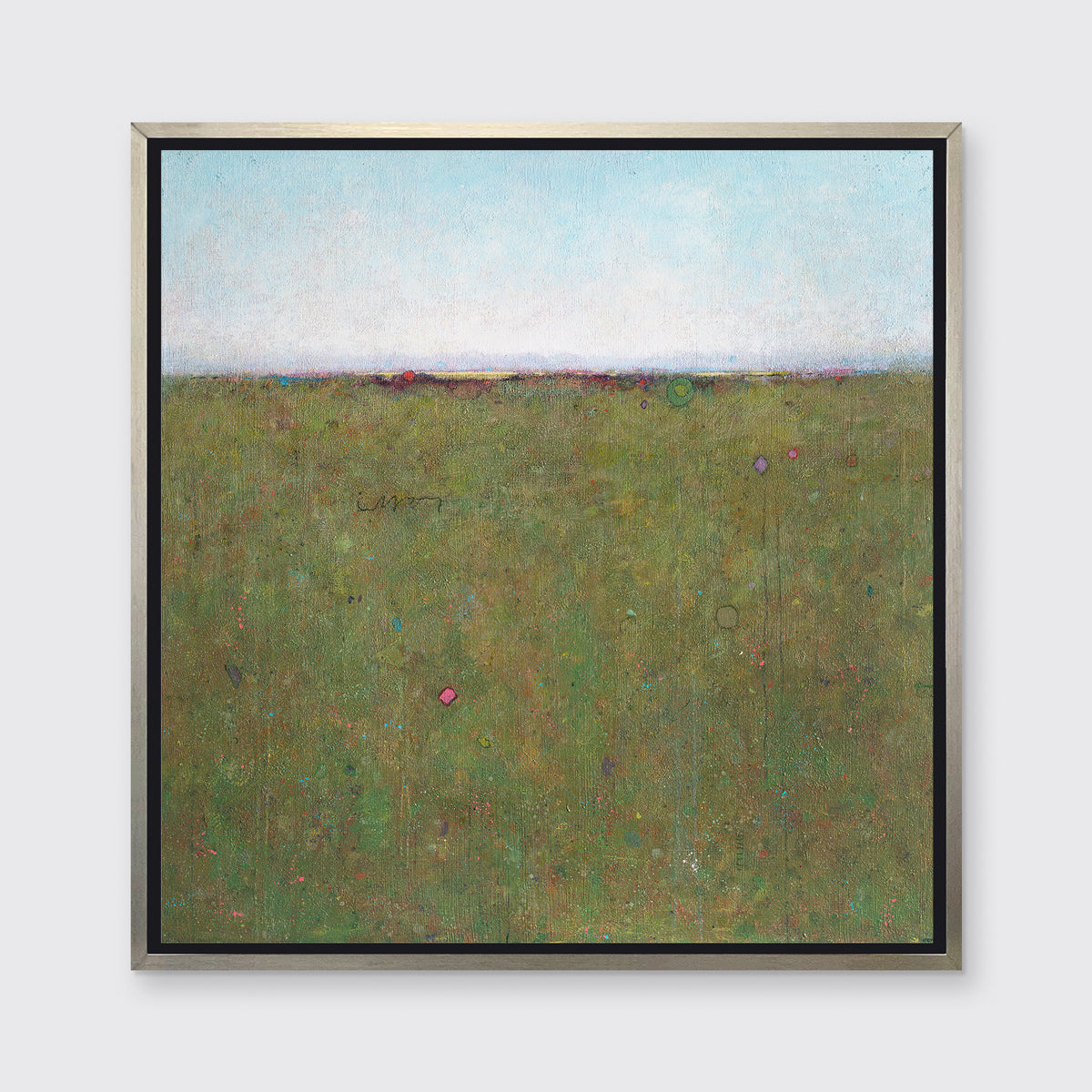 A green and blue abstract landscape print in a silver floater frame hangs on a white wall.