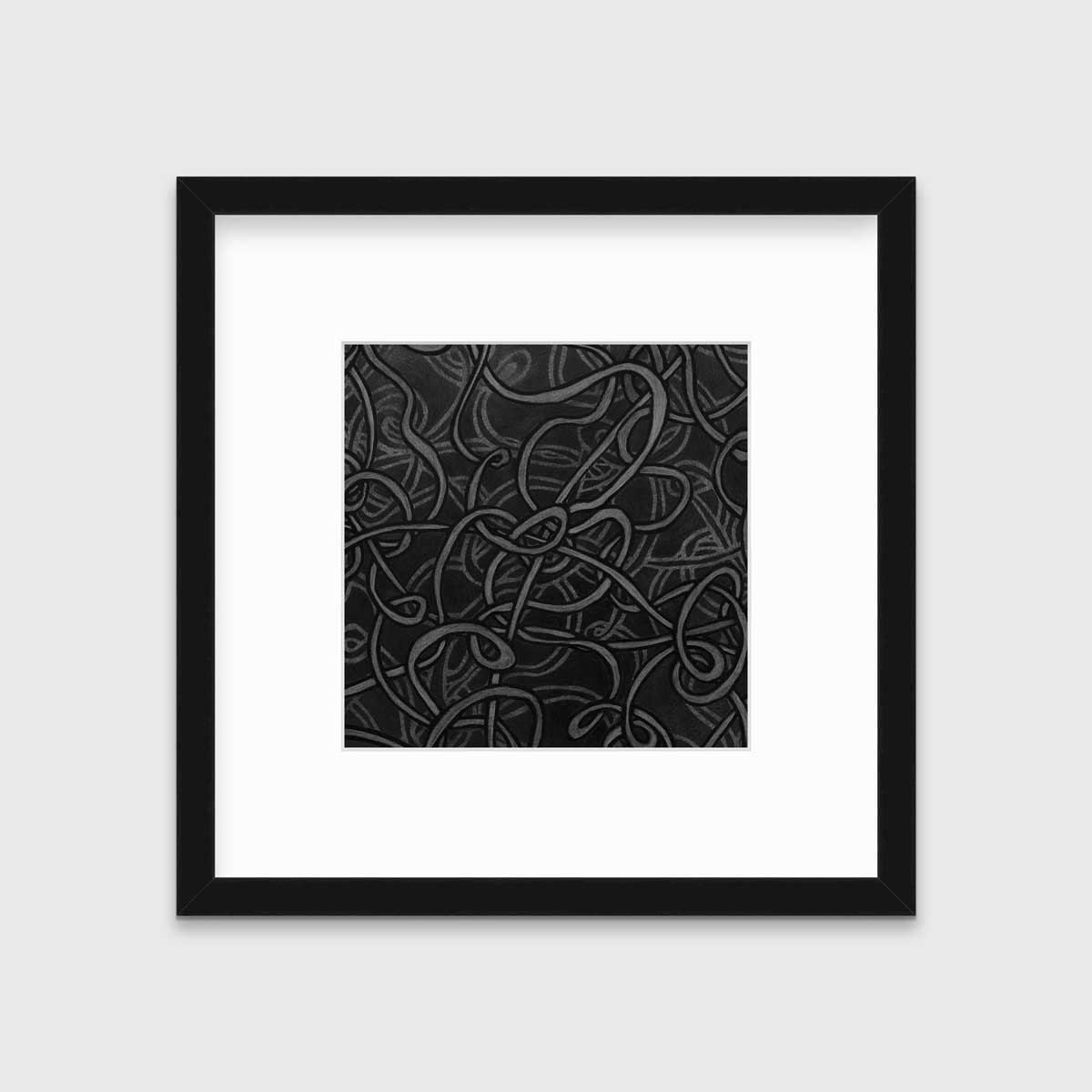 A black and grey abstract print in a black frame with a mat hangs on a white wall.