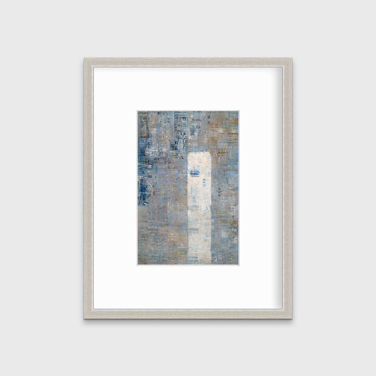A blue and grey abstract geometric print in a silver frame with a mat hangs on a white wall.