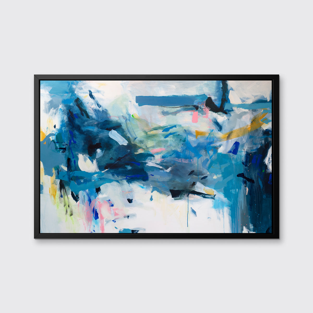 A blue, yellow and white abstract print in a black floater frame hangs on a white wall.