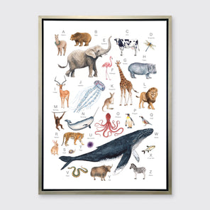 A multicolored print of different animals through the alphabet in a silver floater frame hangs on a white wall.