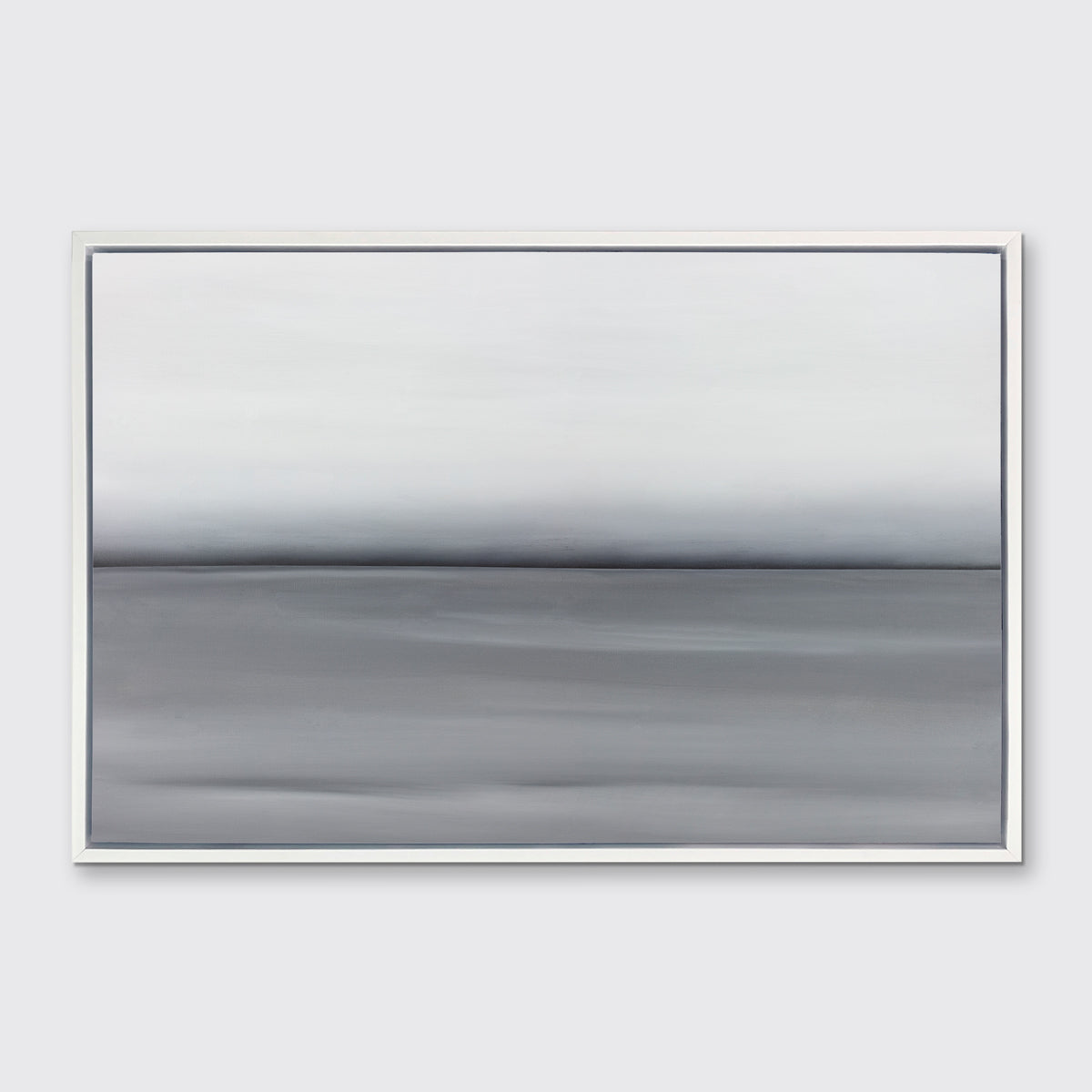 A grey toned abstract landscape print in a white floater frame hangs on a white wall.