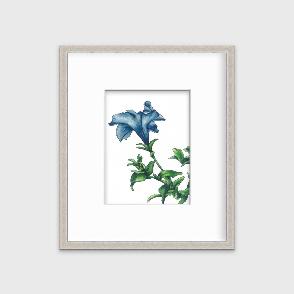 A blue and green flower print in a silver frame with a mat hangs on a white wall.