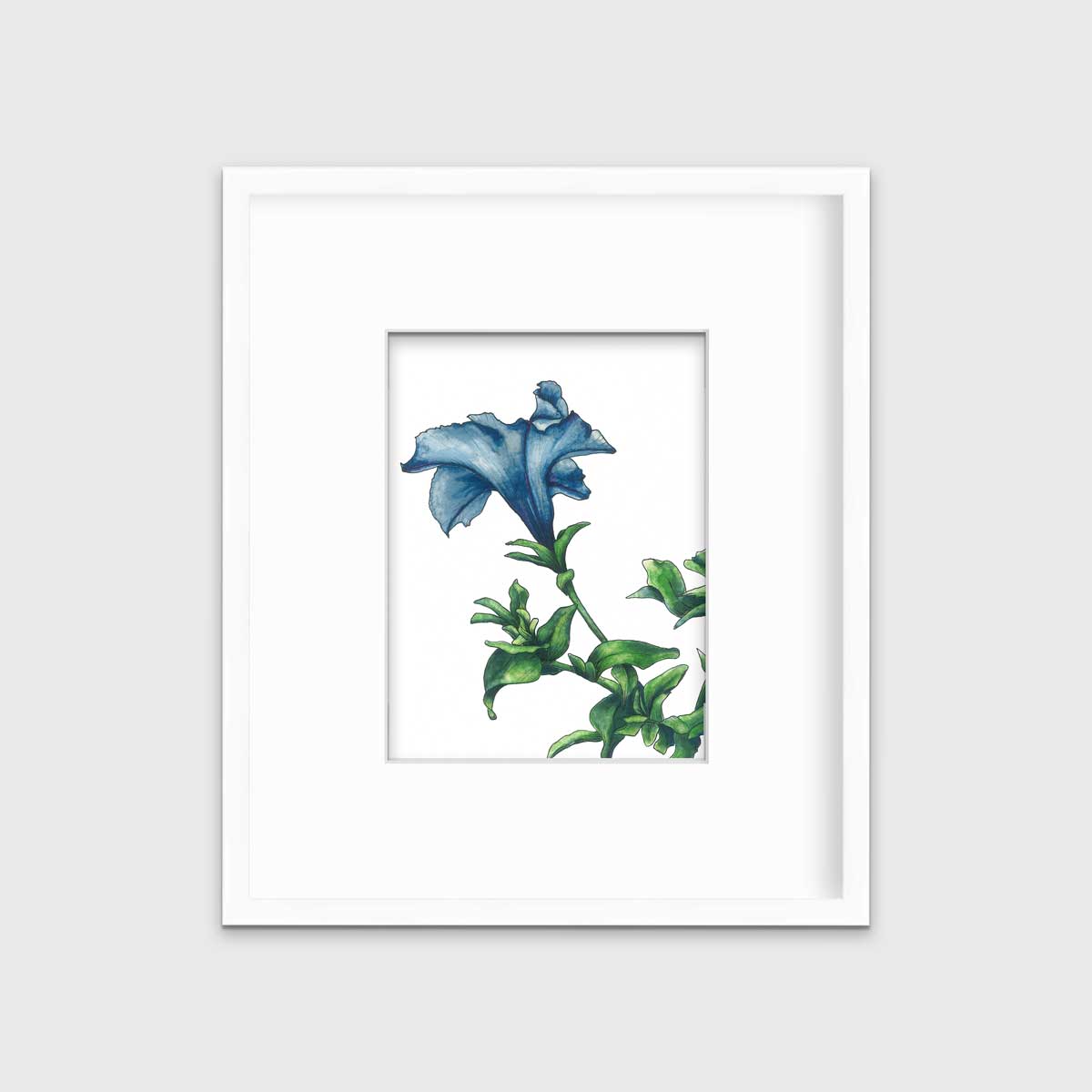 A blue and green flower print in a white frame with a mat hangs on a white wall.