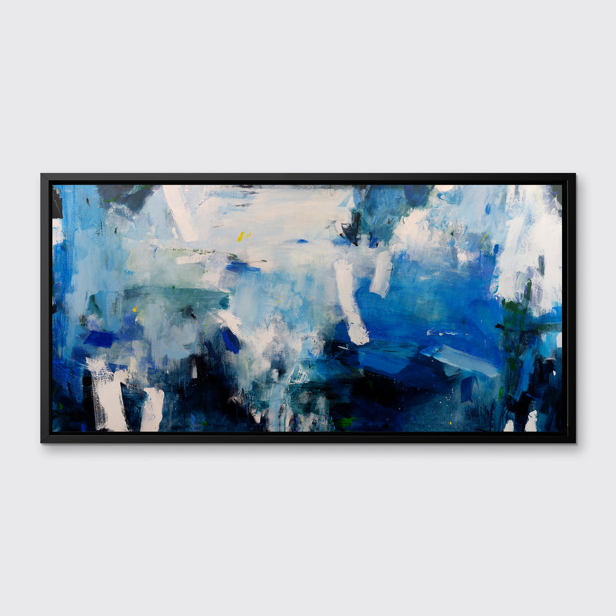 A blue, white and black abstract print in a black floater frame hangs on a white wall.